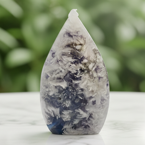Moss agate teardrop with marble bokeh background